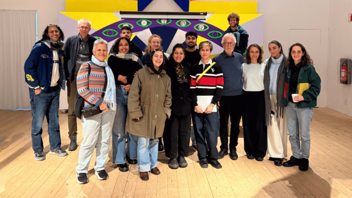 Besökande grupp uppställda för gruppfoto i utställningen Skuld.